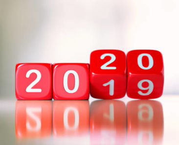 Red dices are changing from 2019 to 2020. Numbers are engraved on dices. Dices are lit from the upper left corner of the composition and casting shadows over defocused background. New year and change concept. Horizontal composition with copy space.